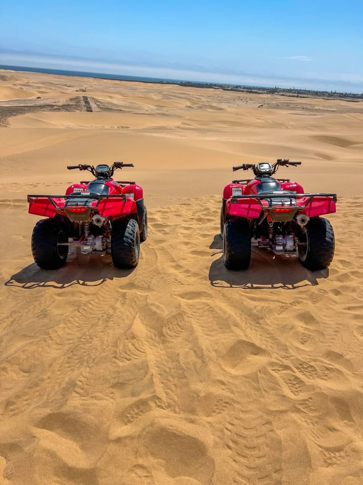 Red quad bikes parked on golden sand dunes at Mambrui, Kenya